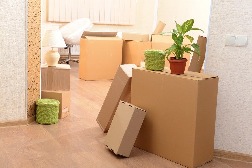 Movers carrying furniture through a typical East London home staircase